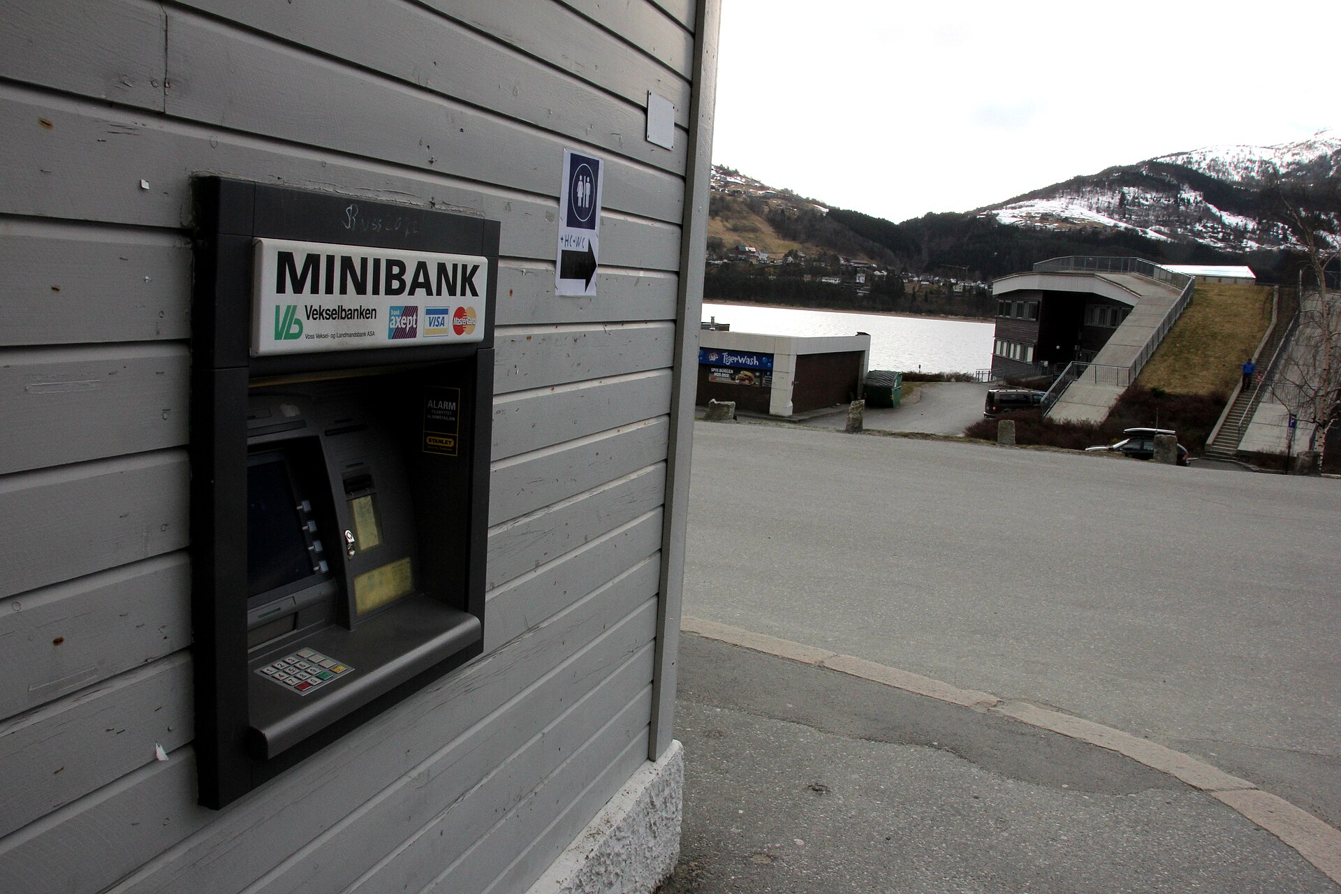 Sportello automatico bancario incassato nel muro con tastierino e schermo acceso