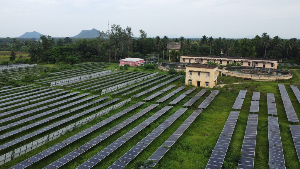Veduta dall'alto di file regolari di pannelli fotovoltaici in un campo pianeggiante