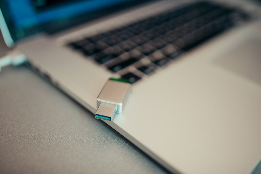 Piccolo dispositivo con connettore metallico tenuto tra le dita in primo piano