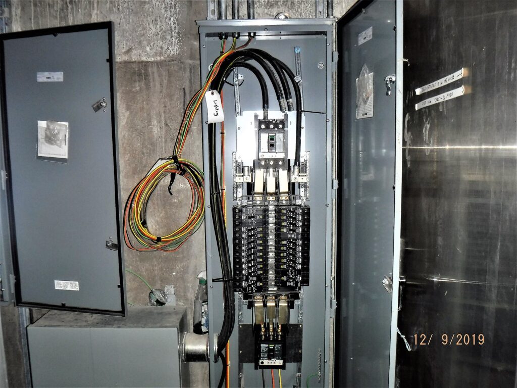 Cabina elettrica con trasformatori e isolatori recintata a bordo di una strada