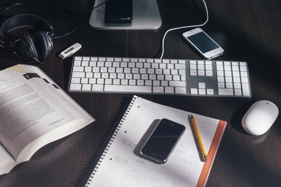 Quaderno aperto con annotazioni e una calcolatrice appoggiata sul piano di lavoro