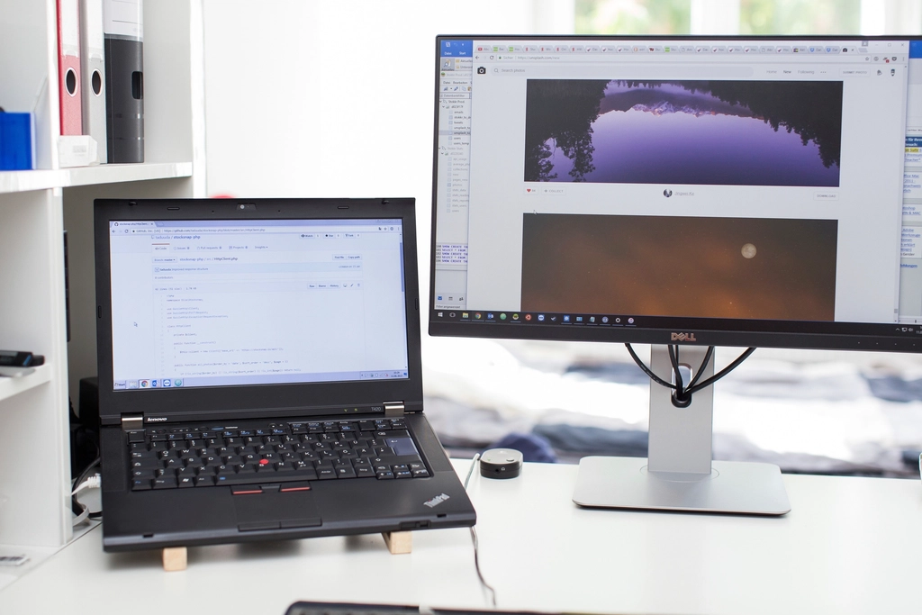 Computer portatile aperto su una scrivania con documenti e una tazza accanto